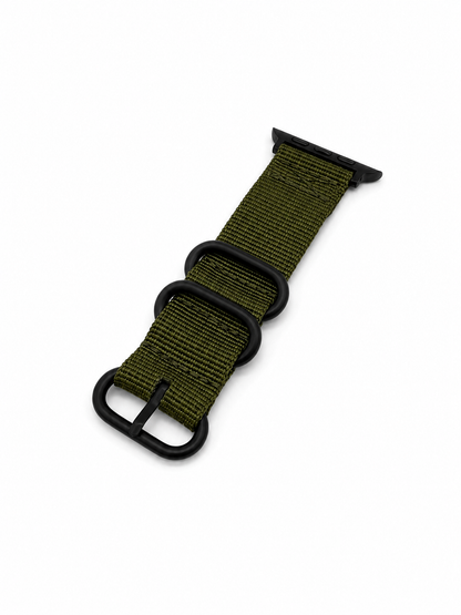 An olive green nylon watch strap with matte black hardware, including a buckle, loops, and connector end, shown on a plain white background.